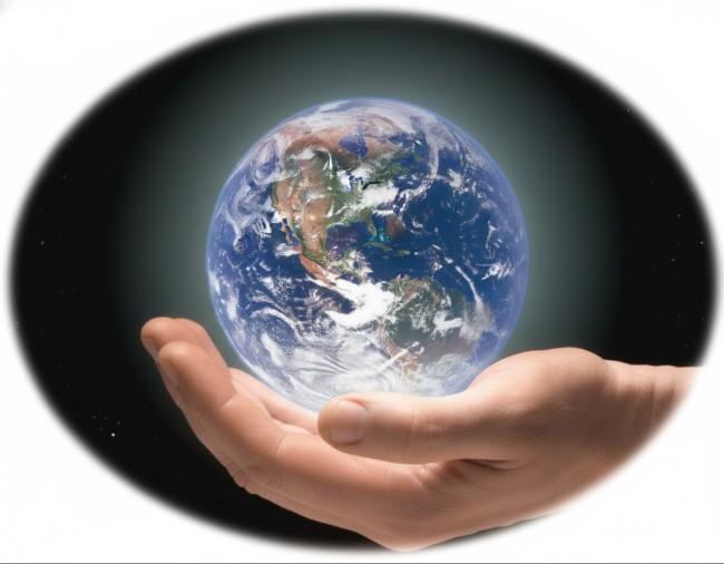A realistic image of a human hand gently cradling a glowing, detailed planet Earth against a dark, cosmic background with a soft vignette.